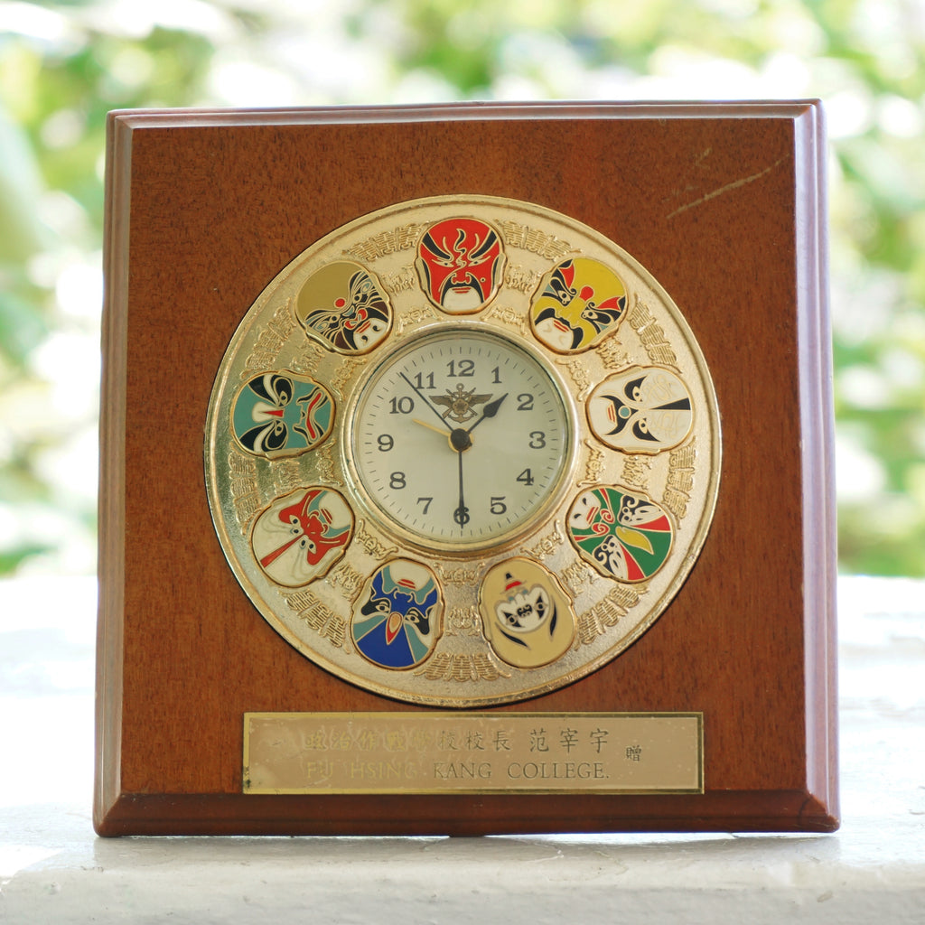 Vintage Fu Hsing Kang College Gold Tone 9 Mask Clock with a Wooden Frame.